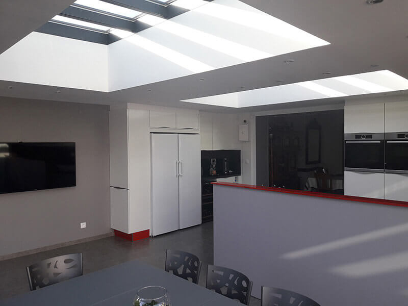 Extension d'habitation de type toiture plate de couleur gris foncé avec 2 dômes mono-pente