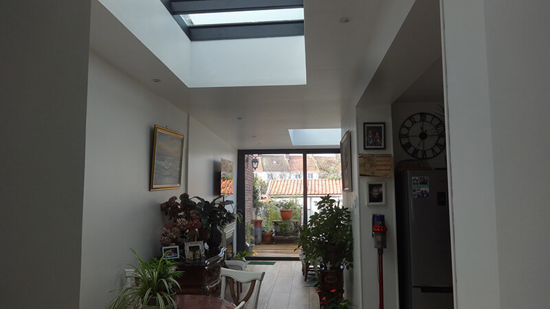Extension d'habitation de type toiture plate de couleur gris foncé avec 3 dômes