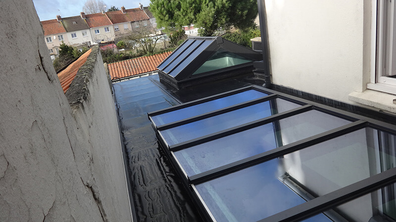 Extension d'habitation de type toiture plate de couleur gris foncé avec 3 dômes