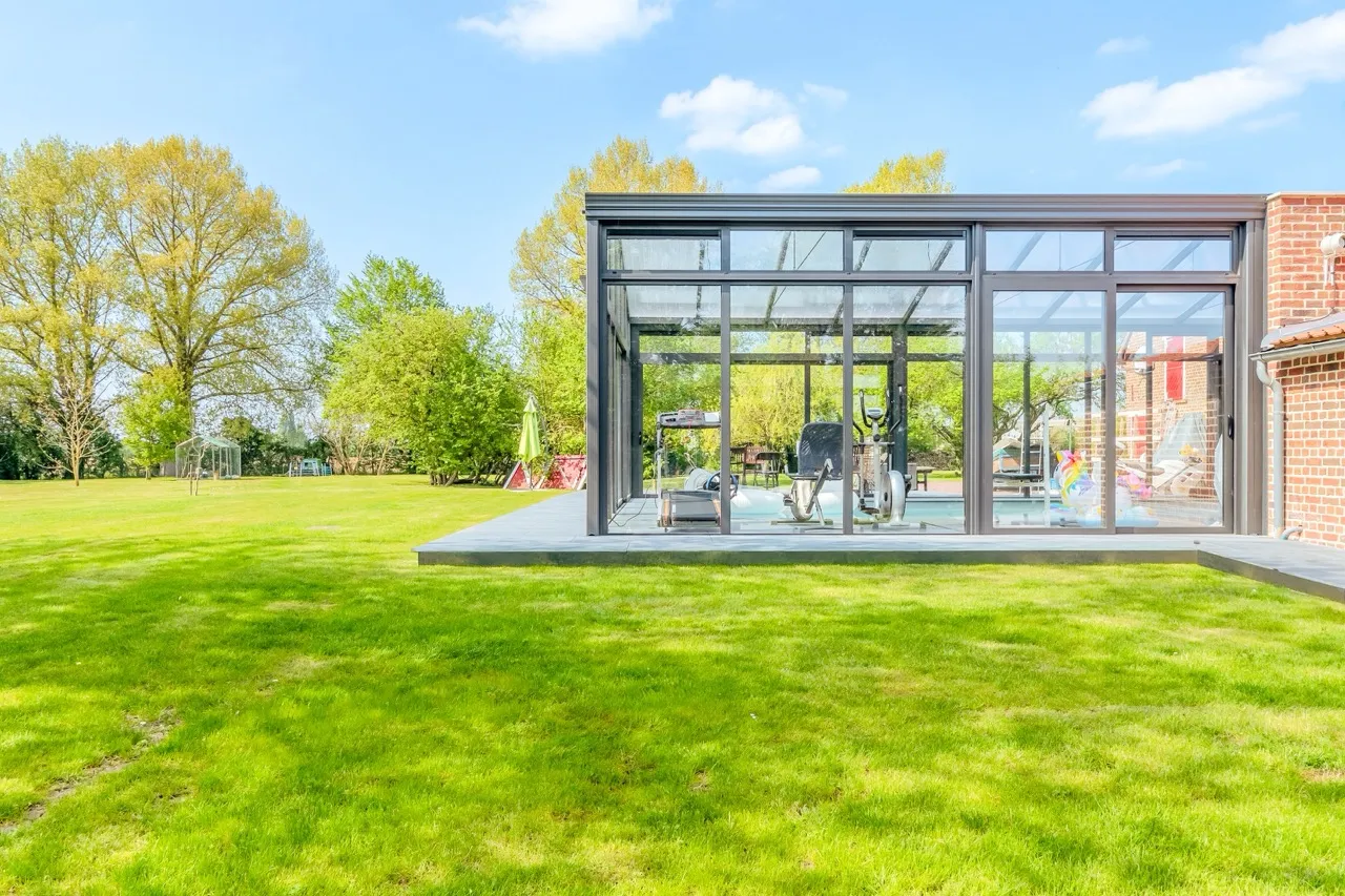 Véranda pour piscine dans un grand jardin arboré